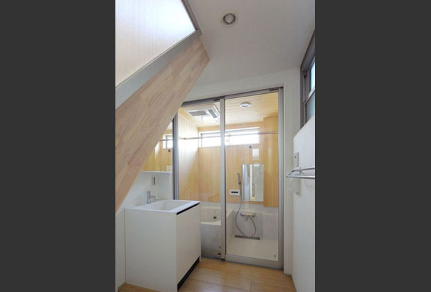 1階洗面脱衣室は階段側の透過性のある壁面により2階からの光をとりこむ