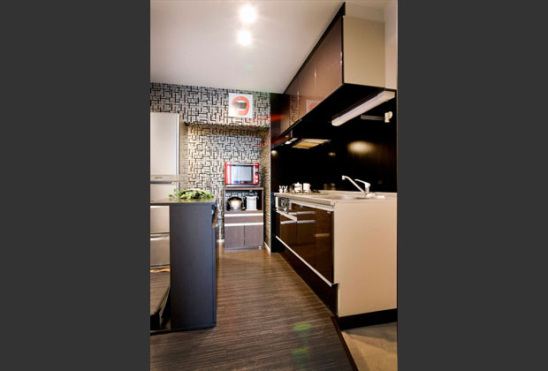 デザイン性のある壁紙や、キッチンパネルの色使いなどでシックな雰囲気にまとめられたダイニングキッチン。