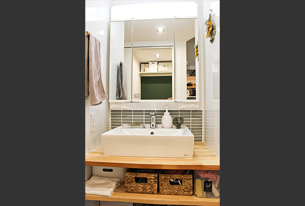 洗面スペースは造作棚と三面鏡で収納場所も確保。自動水栓なので汚れた手で水栓を触らず清潔に手を洗えます。 