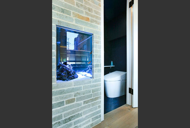 アクアリウムがあるトイレは、床～壁～天井と濃紺に統一し、アクアリウムをじっくり楽しめる環境に。